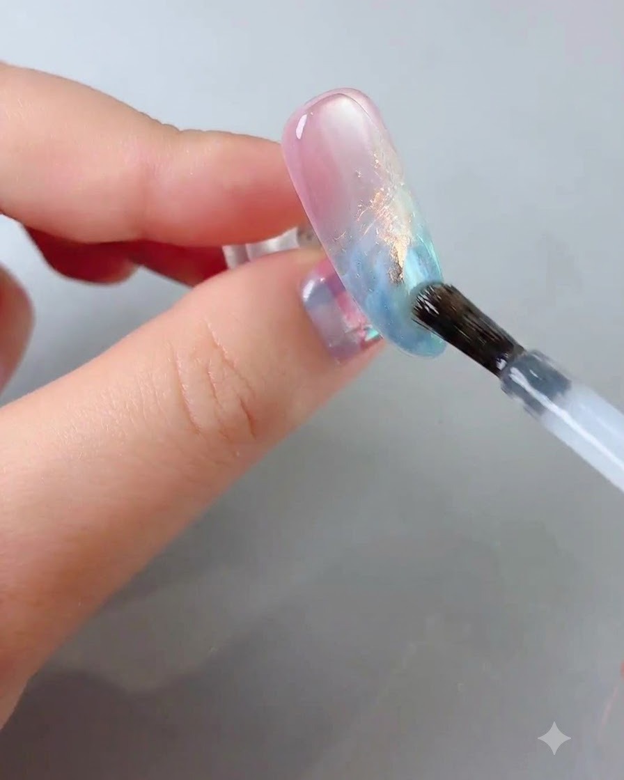 Ein Nagelpinsel lässt einen klaren, glossigen Top Coat sanft über die dekorierte Nageloberfläche gleiten.