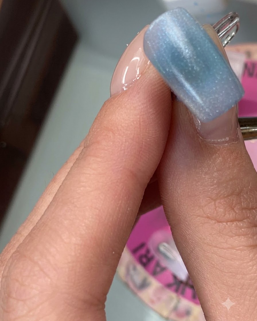 Ein Zeigefinger zeigt eine glatte erste Schicht aus Black Sesame gefärbtem Gel.