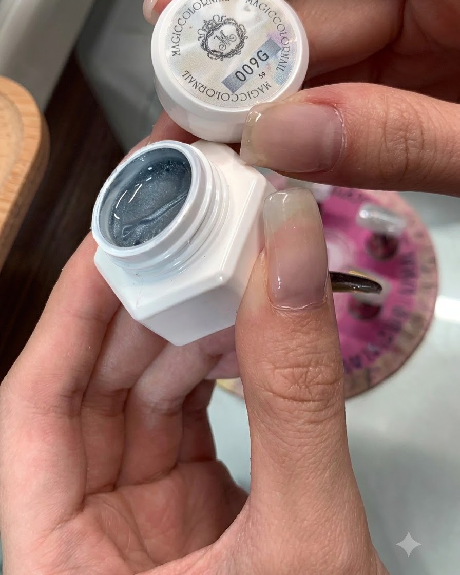 Ein Tiegel mit Cat-Eye-Gel 009 neben einem für das Auftragen vorbereiteten Nagel.