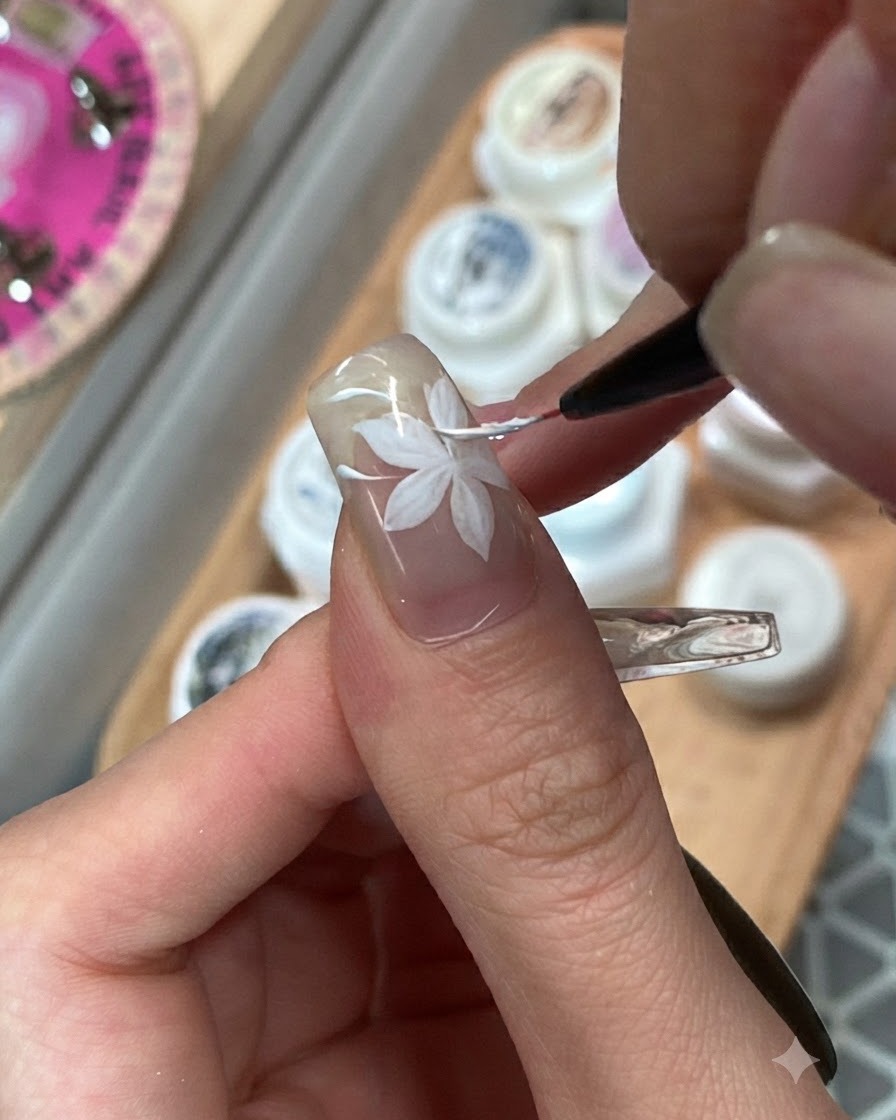 Ein feiner Pinsel verblendet benachbarte pinke und lila Gel-Farbblöcke auf einem Ringfingernagel.
