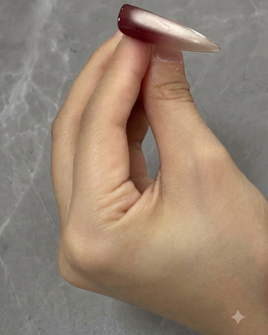 Das Auftragen einer zweiten Schicht Cat-Eye-Gel auf die Nageloberfläche.