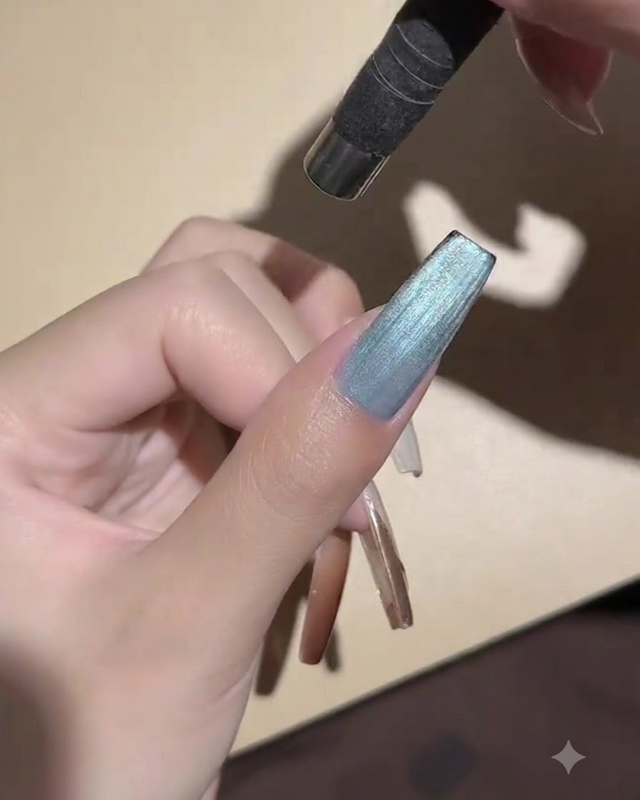 Eine tragbare Mini-UV-LED-Lampe ist direkt über einem lackierten Nagel positioniert, um das Cat-Eye-Gel anzuhärten.