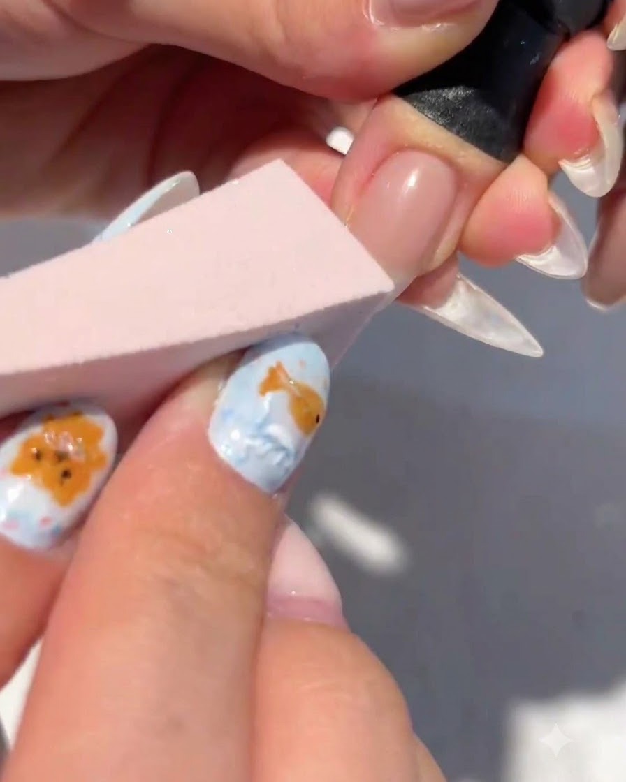 Ein Make-up-Schwamm tupft weißes Gel auf die Nagelspitze, um einen Farbverlauf zu bilden.