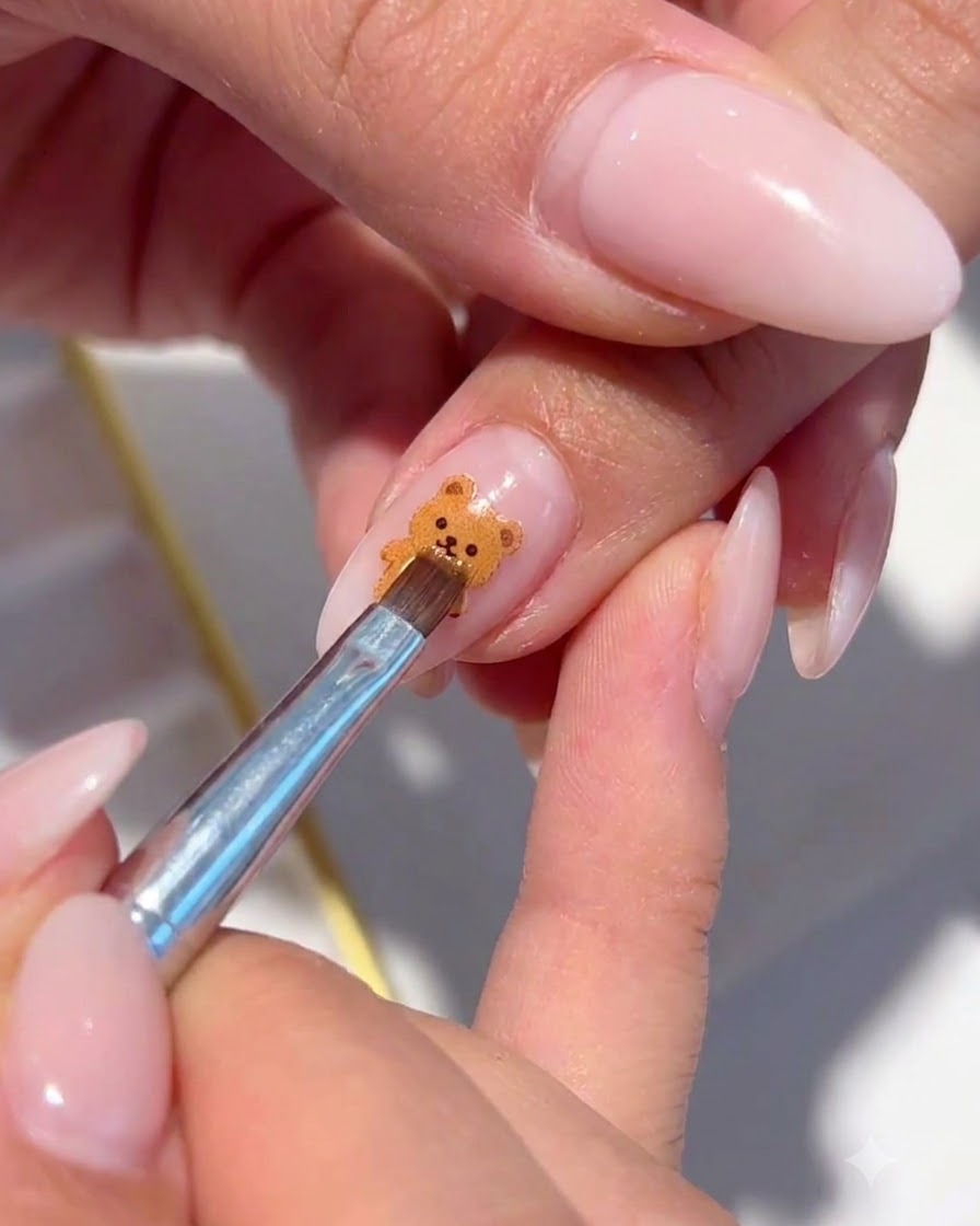 Ein feiner Pinsel platziert irisierende Schimmerflocken um die gemalte florale Nagelkunst herum.