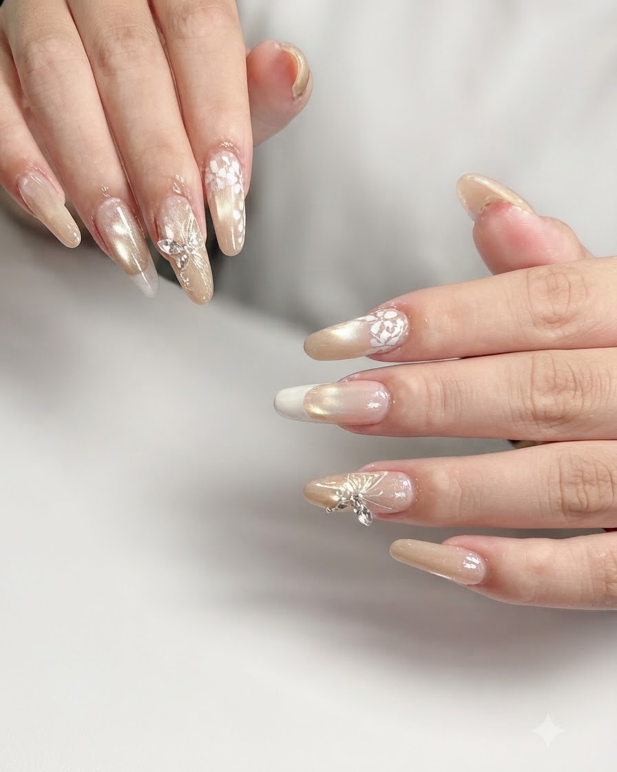 Makroaufnahme eines Ringfingernagels mit filigraner, weißer Spitzennagelkunst auf Nude-Farbverlauf.