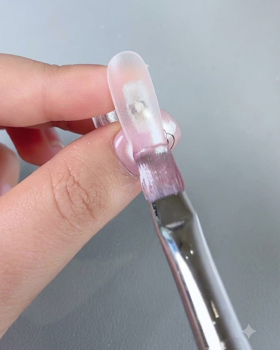 Ein Pinsel trägt klares Wassergel Nr. 3 auf die vordere Kante des Nagels auf.