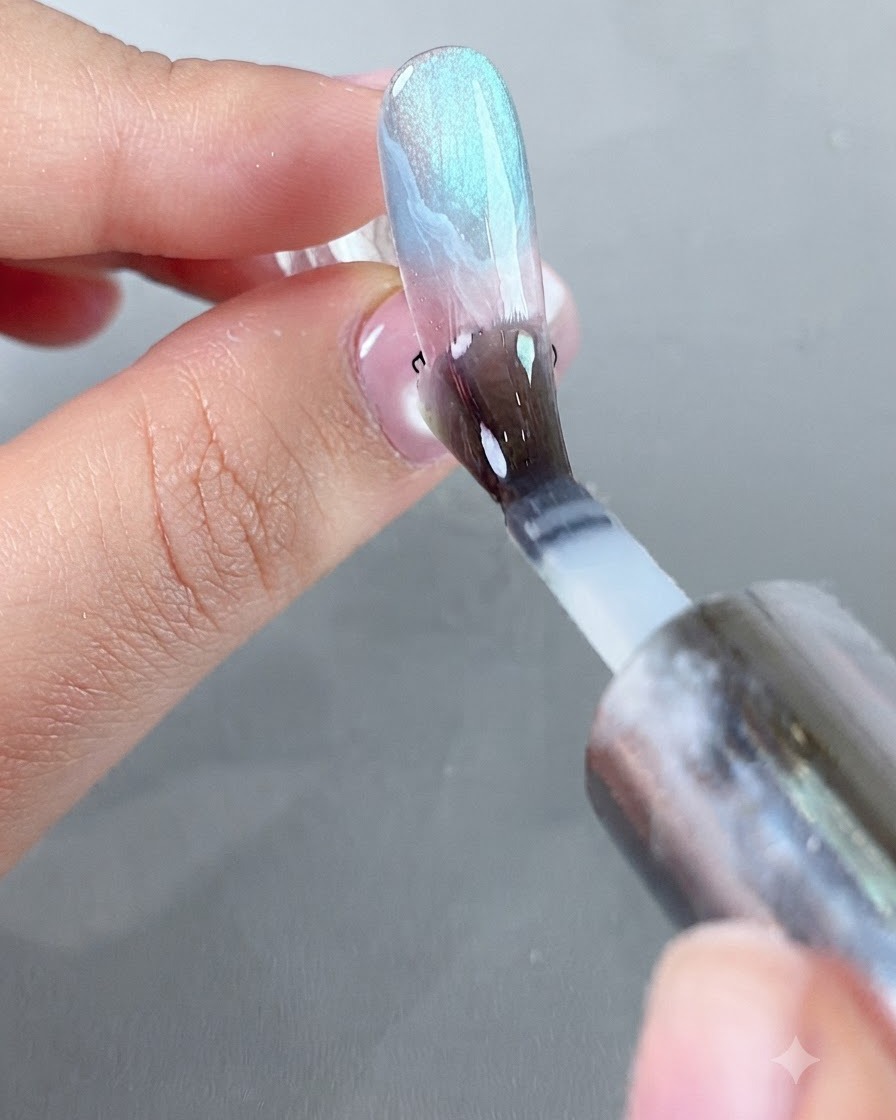 Ein Pinsel trägt eine glatte Schicht eines schützenden, puder-isolierenden Top Coats über die dekorierte Nageloberfläche auf.