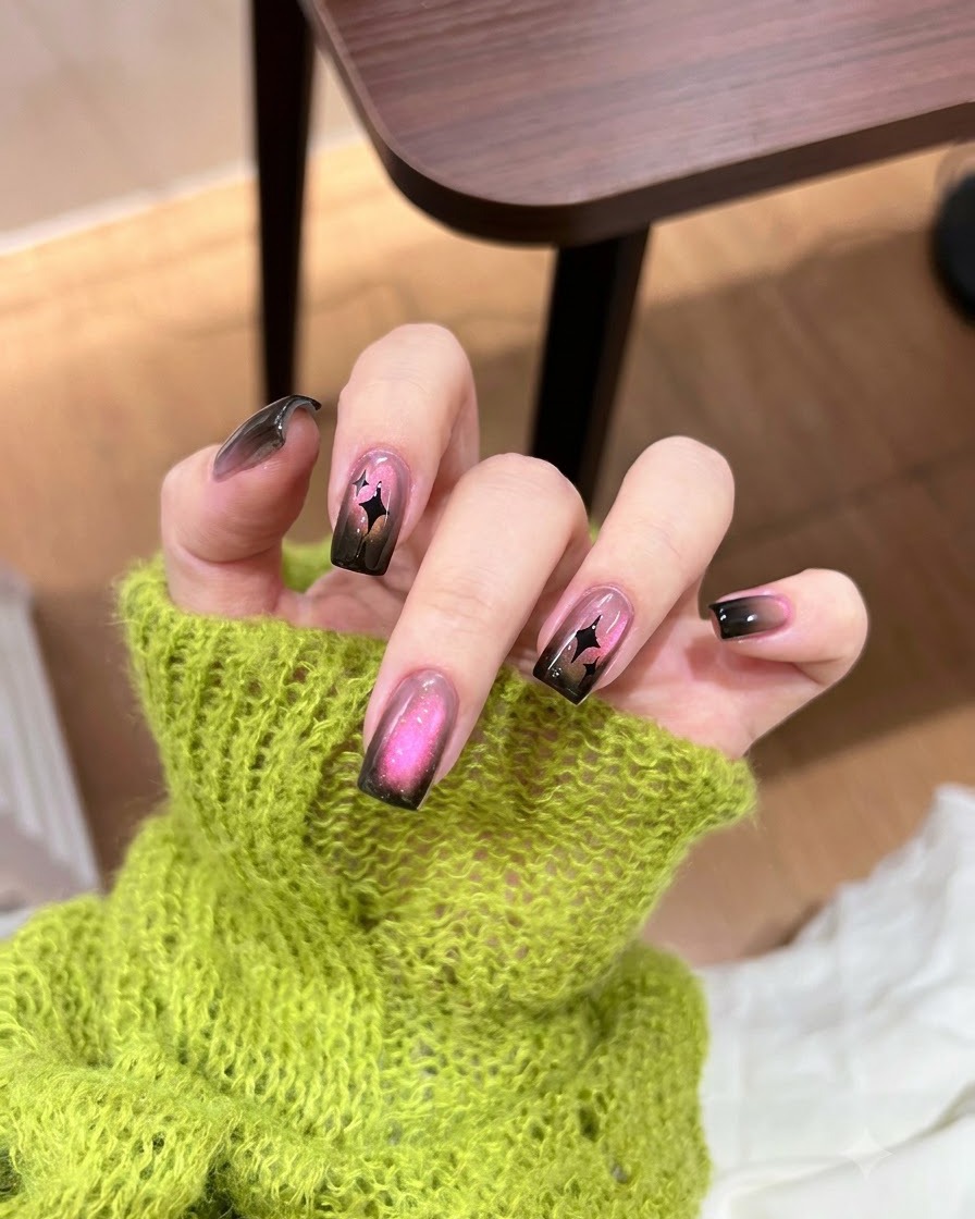 Ein kleiner Schwamm tupft schwarzen Gel-Nagellack auf die Nagelspitze.