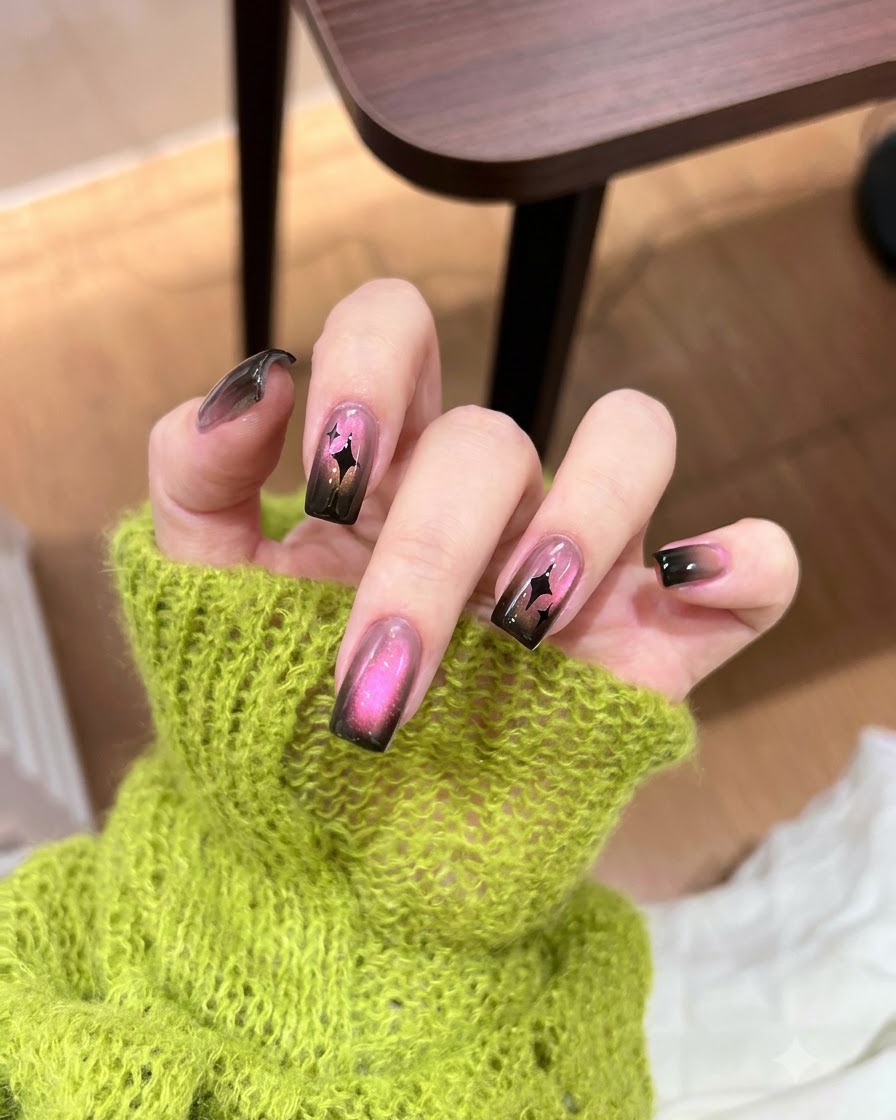 Auftragen eines konzentrierten Klecks dunklen schwarzen Gel-Nagellacks auf die Spitze eines Farbverlaufs-Nagels.