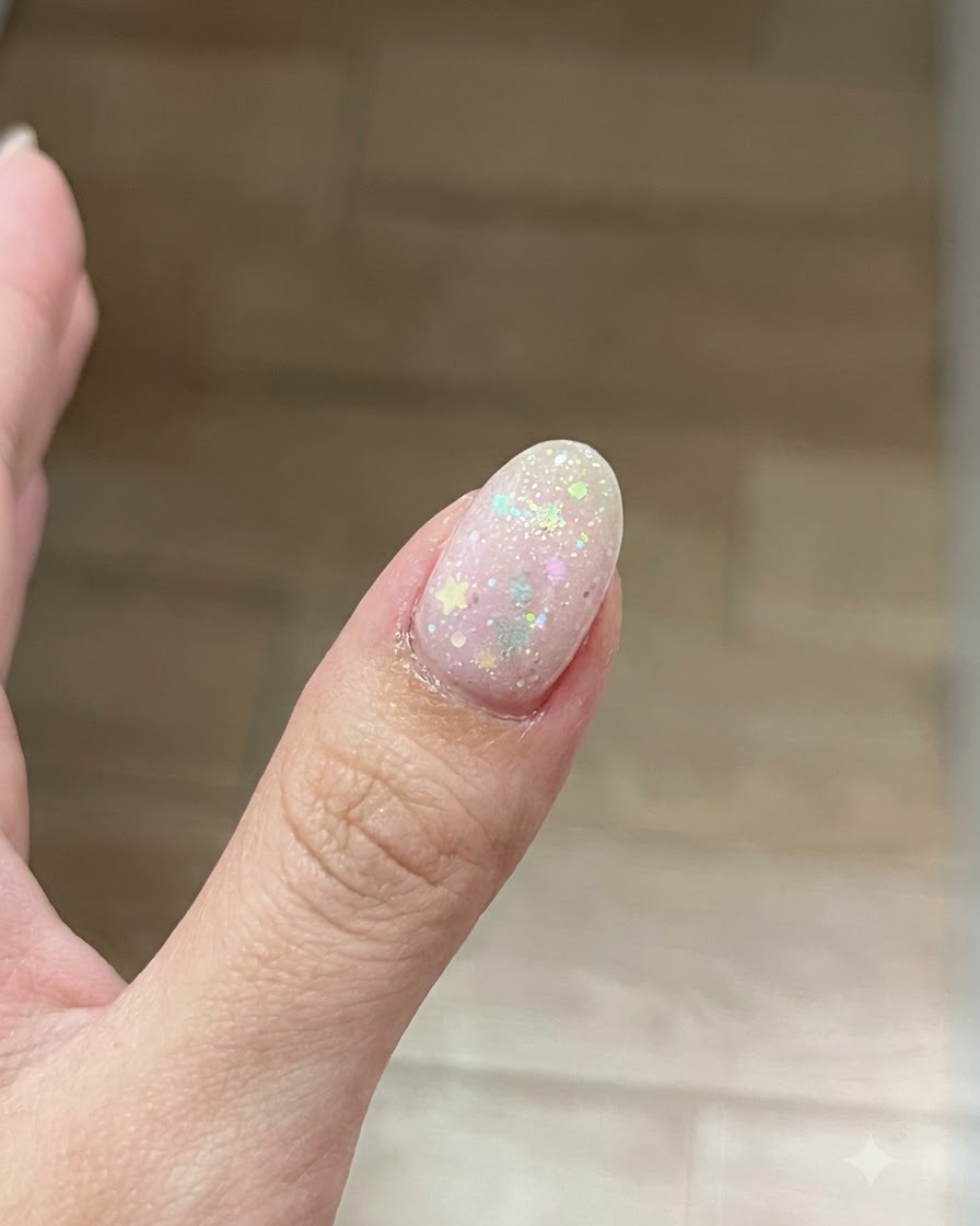 Ein Pinsel trägt eine dünne, klare Schicht Base Gel auf die Oberfläche eines vorbereiteten Fingernagels auf.