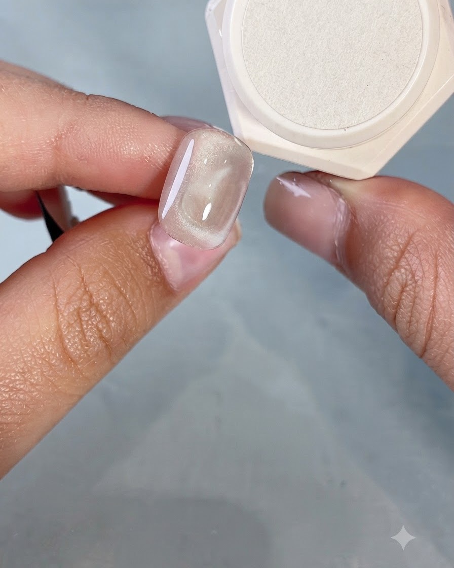 Nahaufnahme eines Nagelpinsels, der einen kleinen Herzumriss auf ein bestehendes Cat-Eye-Herz-Design malt.