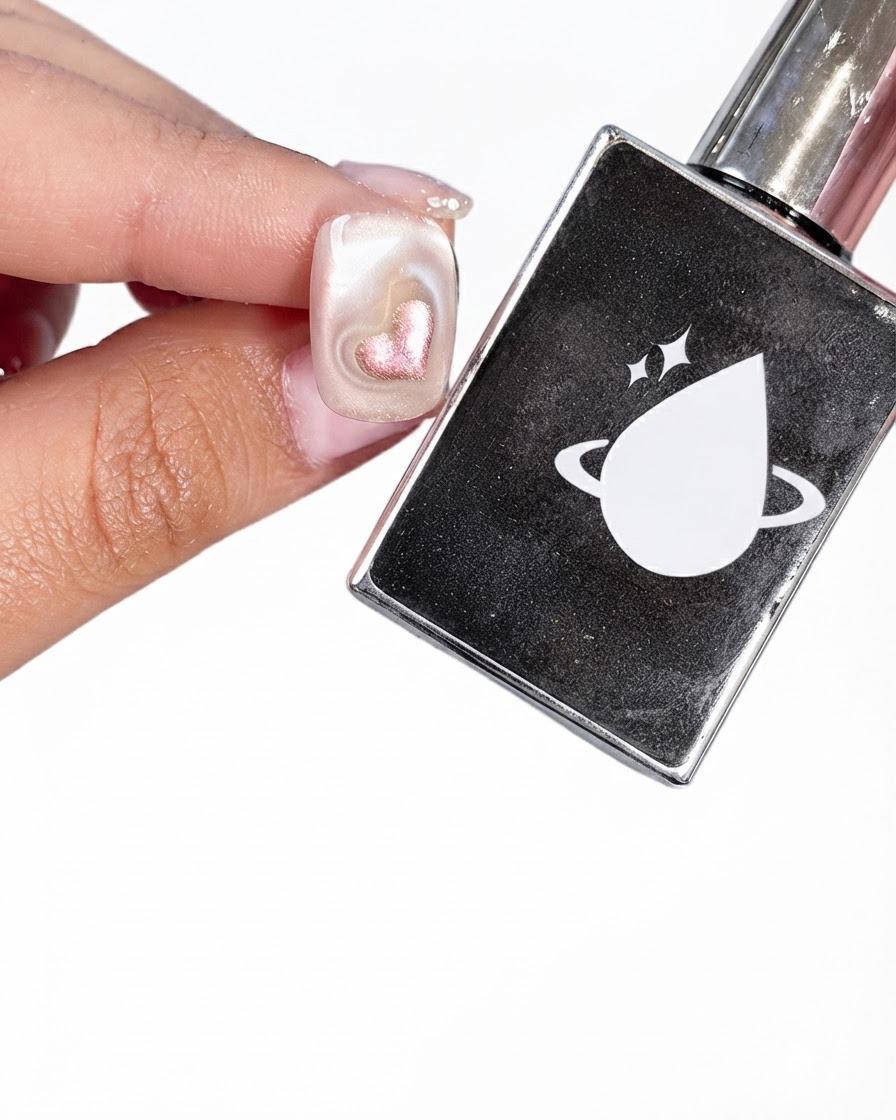 Ein vorbereiteter Nagel neben einer schwarzen Top-Coat-Flasche mit weißem Planeten- und Tropfen-Logo.
