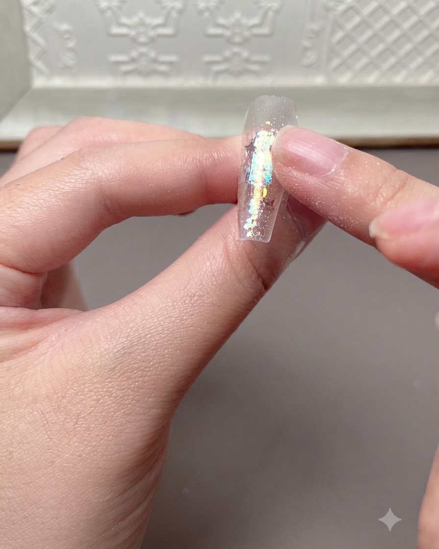 Ein Finger, der leicht auf eine ausgehärtete Nageloberfläche drückt, nachdem sie unter einer UV- oder LED-Lampe war.
