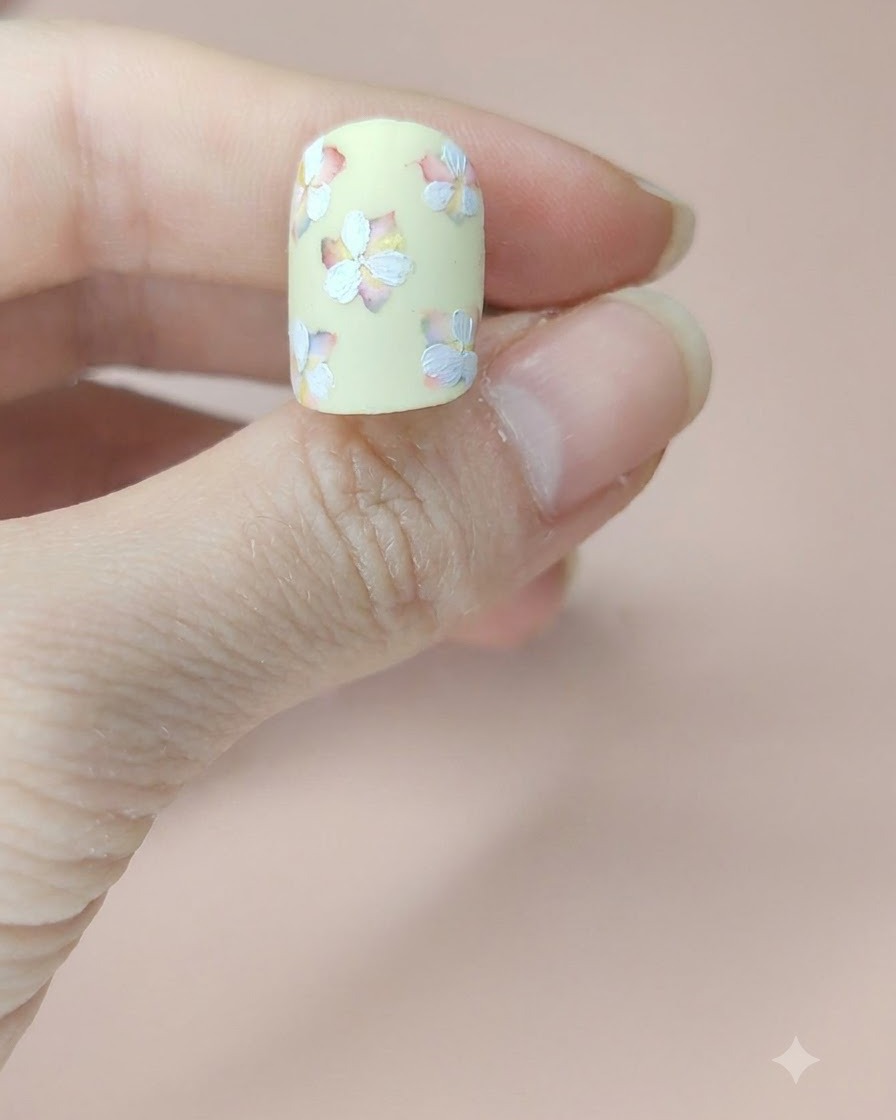 Eine Nahansicht des Nagels, auf dem alle Blumen mit ihrer vollständig gemalten zweiten Schicht weißer Blütenblätter zu sehen sind.