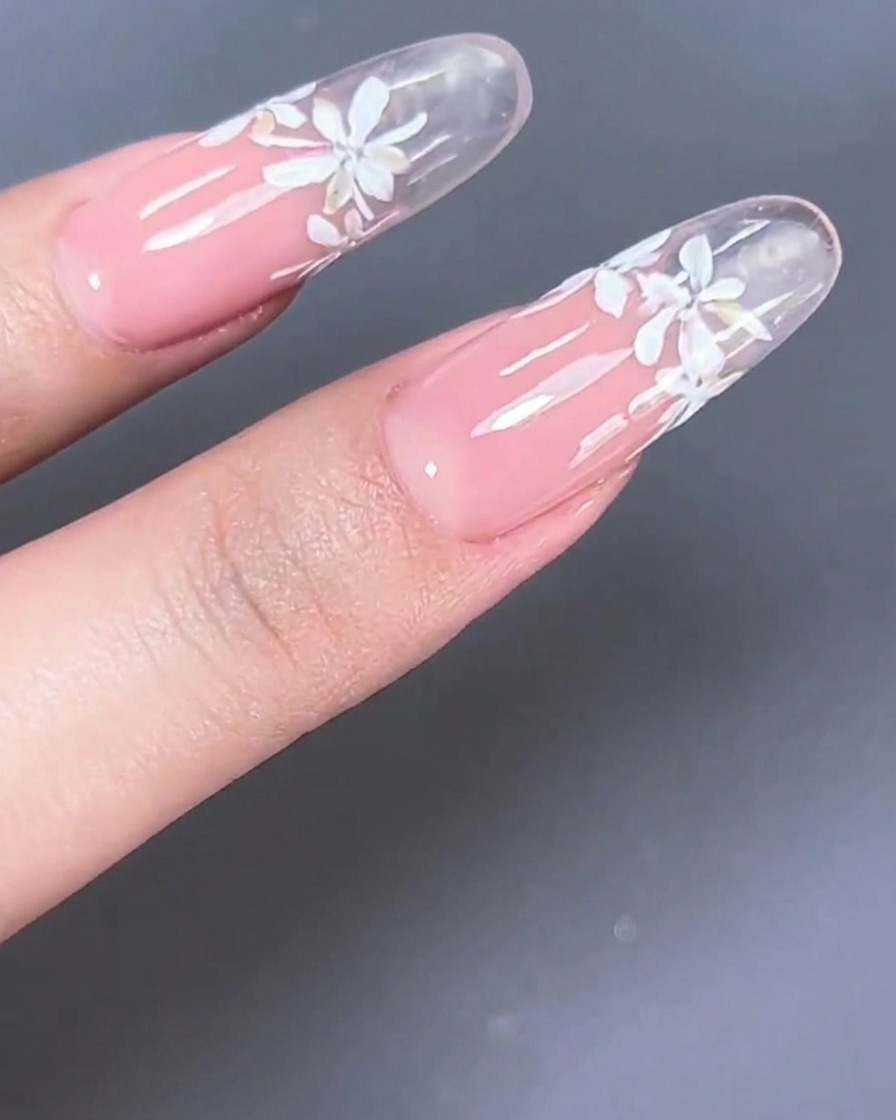 Ein transparenter Nageltipp, der zeigt, wie milchig-rosa Gel auf den Nagelbettbereich aufgetragen wird.