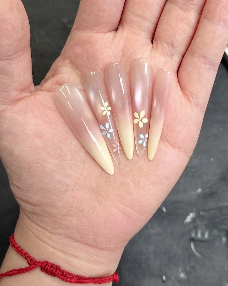 Ein Pinsel trägt eine klare Versiegelungsschicht über das dekorierte Nageldesign auf.
