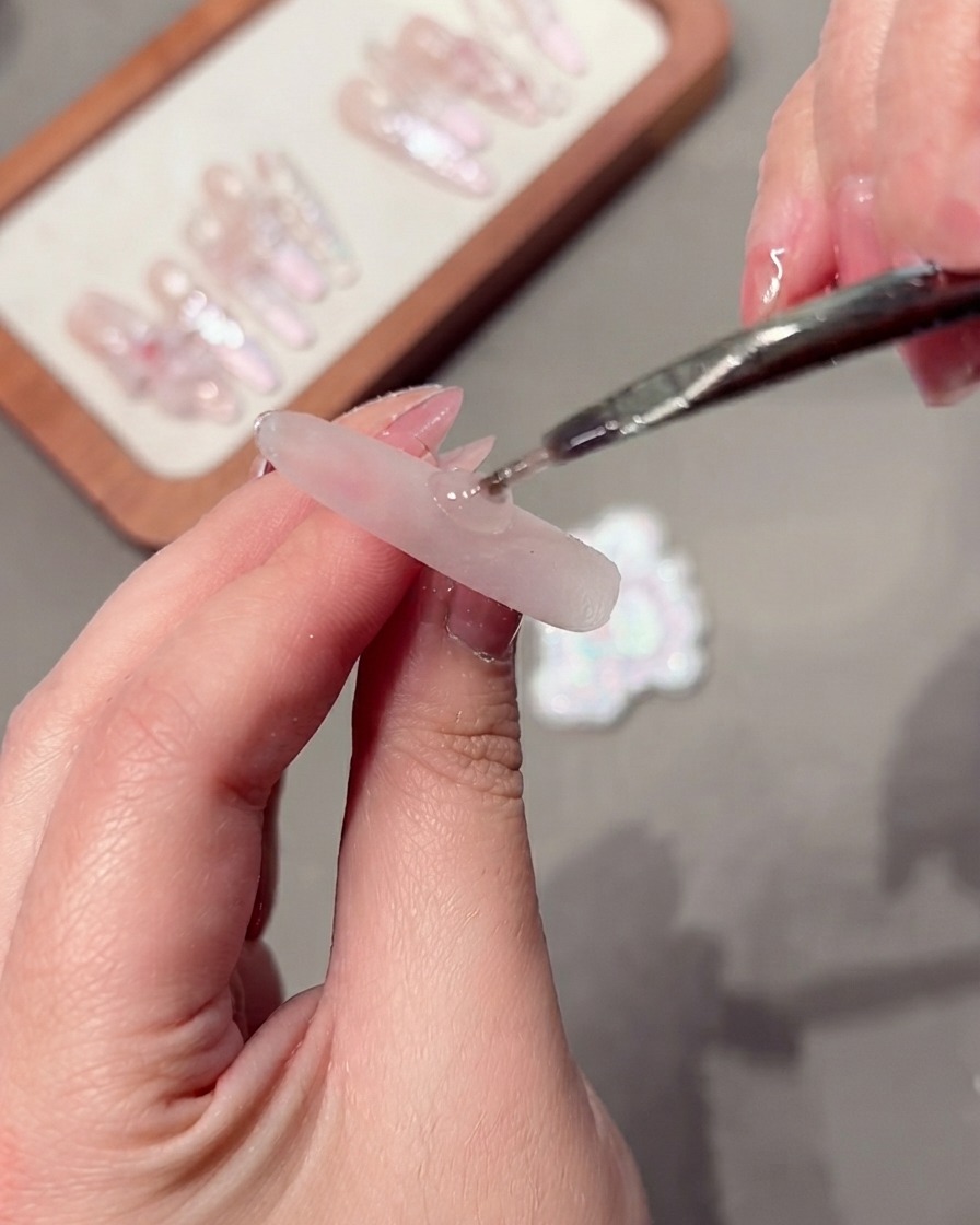 Ein Werkzeug manipuliert Cat-Eye-Gel-Partikel auf einem Nagel.