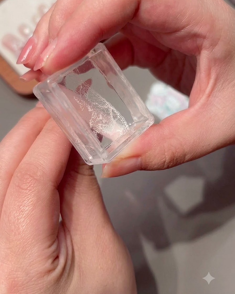 Ein transparenter Stempel hält ein übertragenes Spitzenmuster.