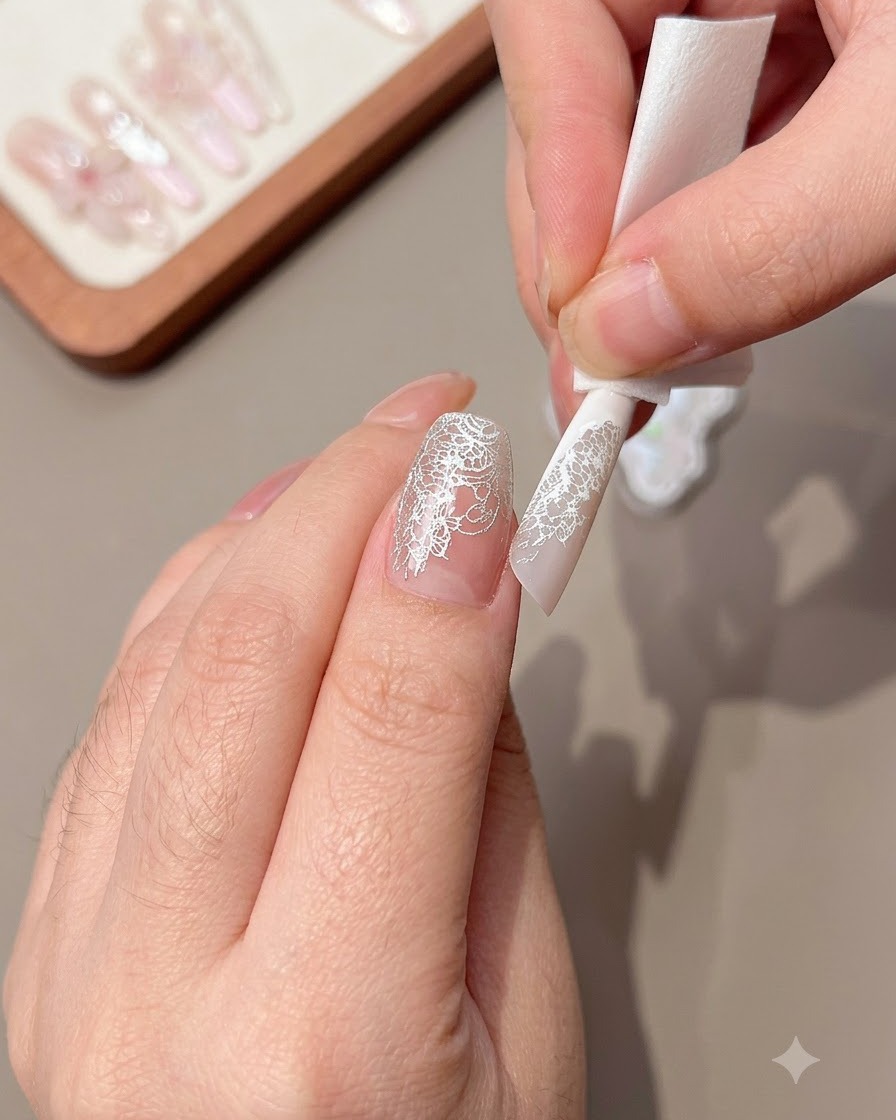 Nahaufnahme einer Hand, die überschüssiges Spitzenmuster vom Nagelrand wischt.