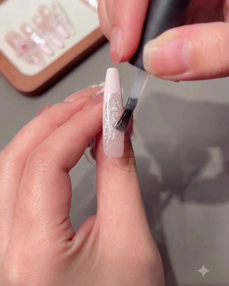Ein Pinsel trägt eine klare Aufbau-Gel Schicht auf einen langen Nagel auf.