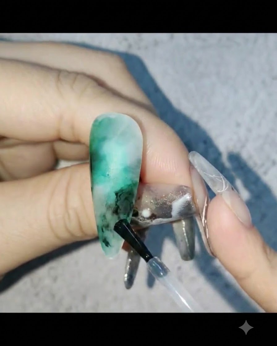 Milchiges Gel wird in die leeren Bereiche des Nageldesigns gegeben und nach außen hin verblendet.