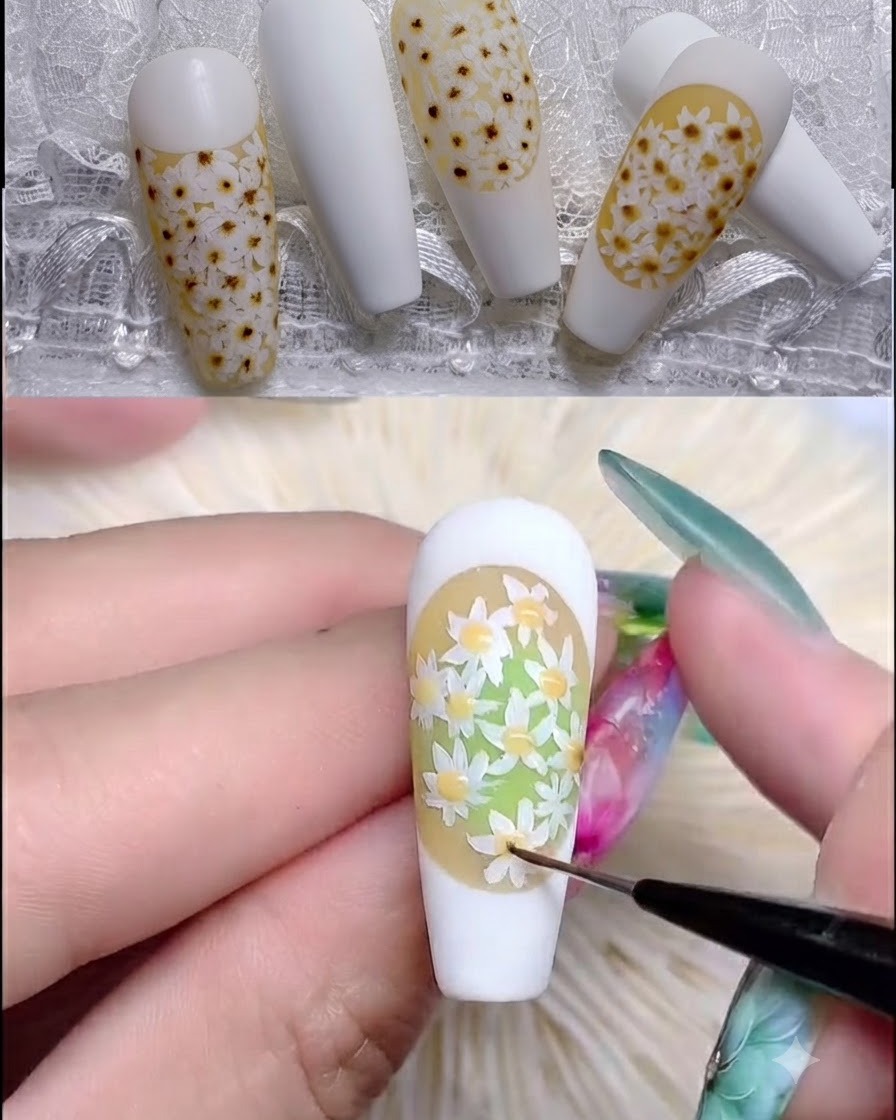 Ein Nagelpinsel trägt klaren Rubber Top Coat über ein strukturiertes Gänseblümchen-Nageldesign auf.