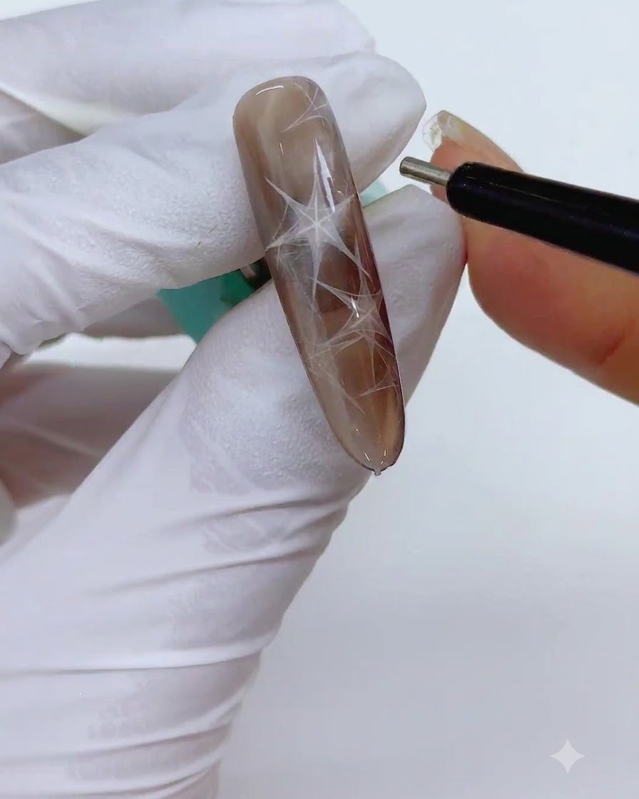 Ein feines zylindrisches Magnetstiftwerkzeug wird in der Nähe des Nagels gehalten, um die Kanten der magnetischen Dreiecksform zu schärfen.