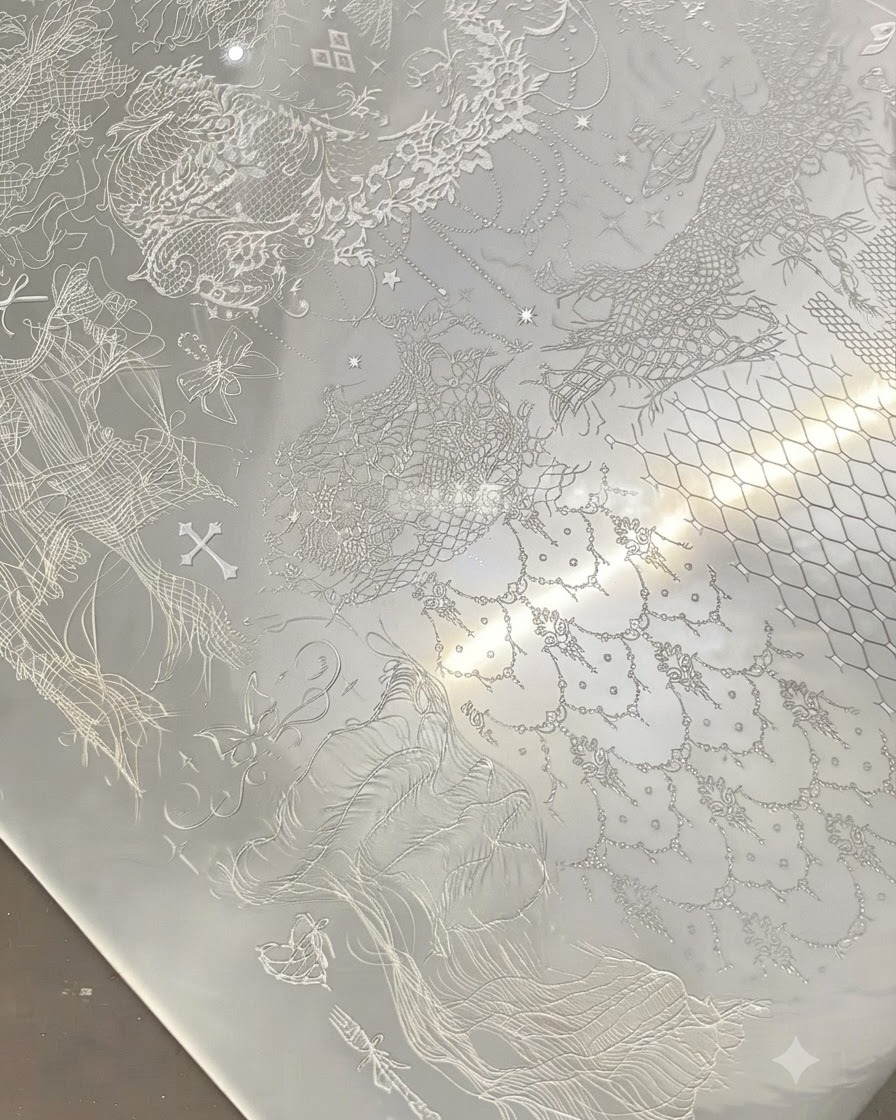 Ein durchsichtiger Stamper drückt auf eine metallene Stamping-Schablone mit filigranen weißen Spitzenmustern.