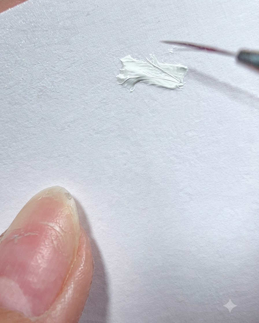 Ein feiner Linienpinsel nimmt weiße Gel-Farbe von einer weißen Oberflächenpalette auf.