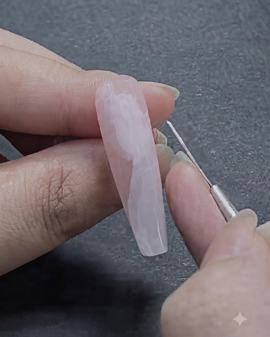 Ein feiner Nail-Art-Liner-Pinsel zieht zarte weiße Linien auf das halb verblendete Blooming-Gel-Banddesign.