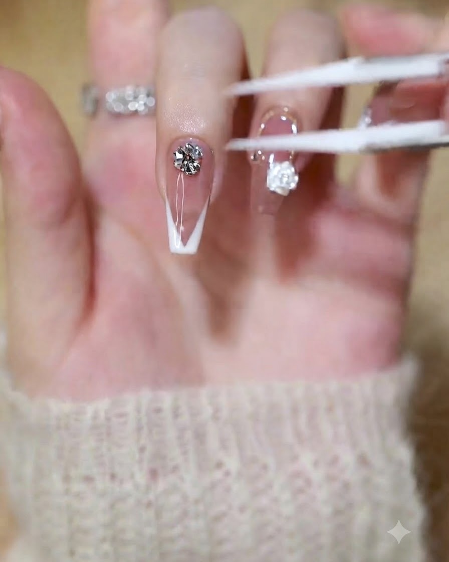 Ein Pinsel oder Werkzeug trägt klaren Builder Gel auf die Spitze eines French-Maniküre-Nagels auf.