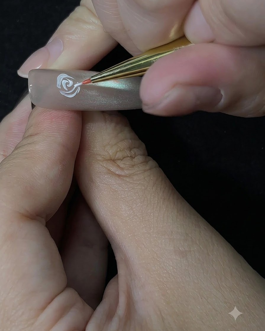 Ein Detailpinsel baut mit einer Tupfbewegung auf dem Nagel die äußeren Rosenblätter auf.