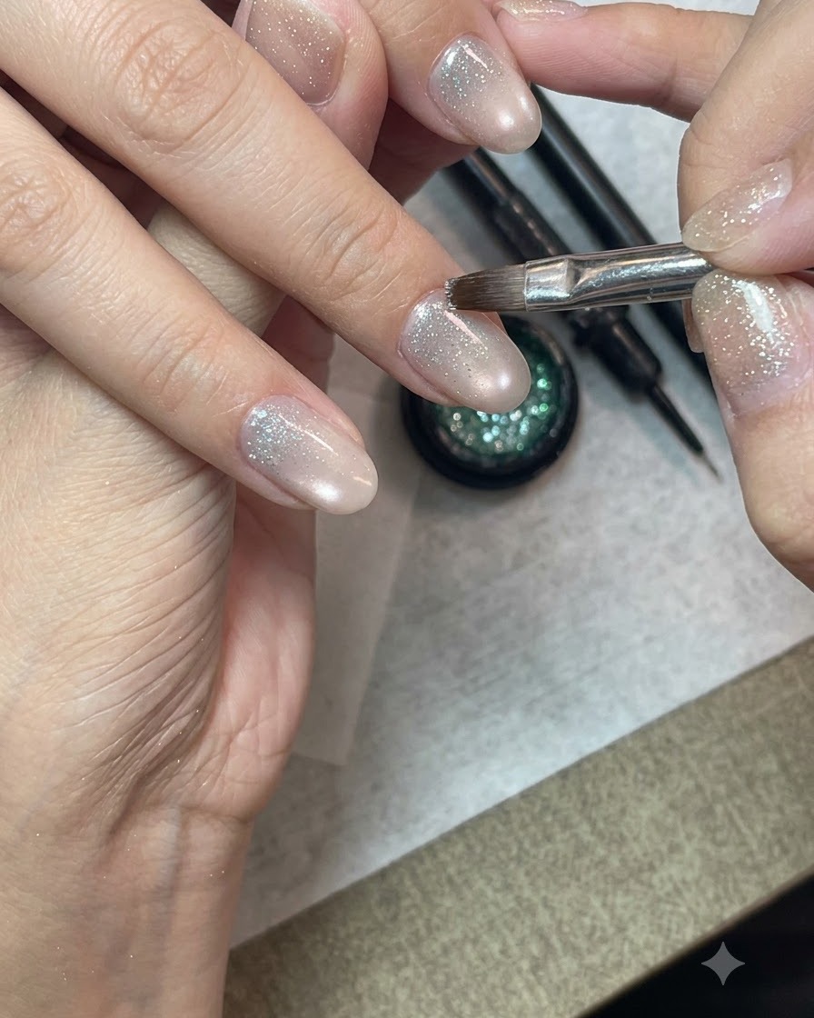 Ein detaillierter Nail-Art-Pinsel, der Crushed-Diamond-Glitzergel auf die untere Hälfte eines vorbereiteten Fingernagels aufträgt.