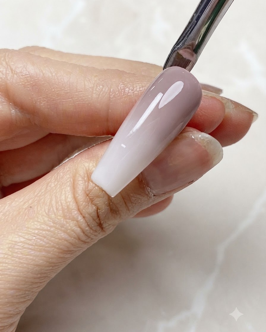 Durchsichtiges milchig-weißes Gel wird auf die Nagelspitze eines Gradienten-Nagels aufgetragen.