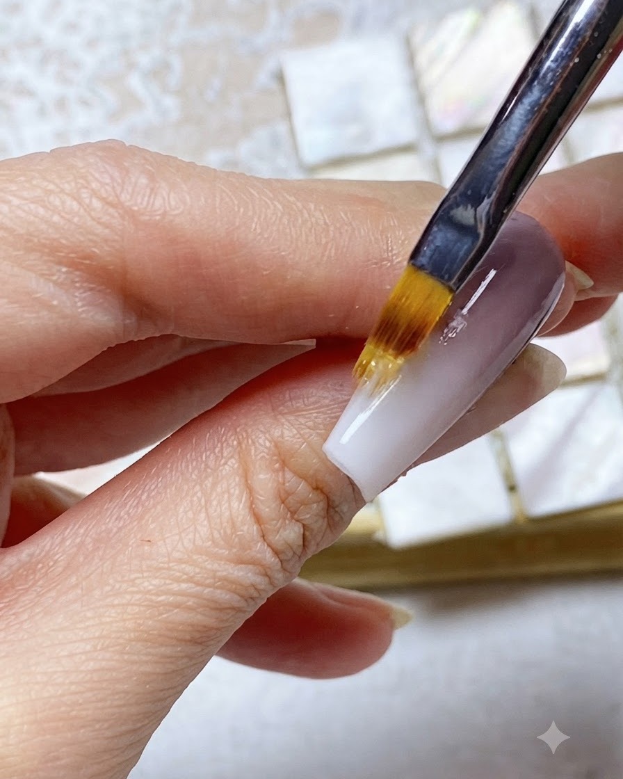 Ein Ombré-Pinsel verblendet das weiße Nagelspitzen-Gel nach oben in den oberen lila Nagelabschnitt.