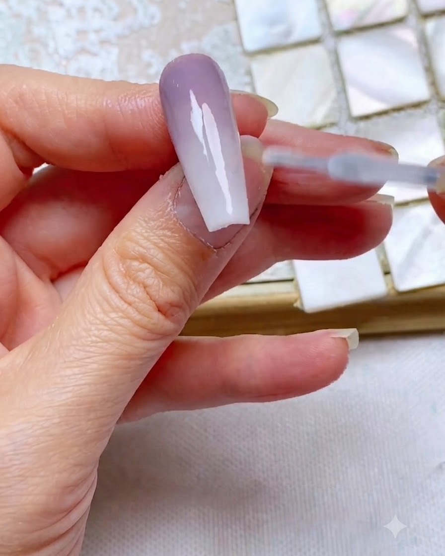 Ein Top-Coat-Pinsel gleitet sanft über einen fertigen Two-Tone-Gradienten-Nagel, um ihn zu versiegeln und Glanz zu verleihen.