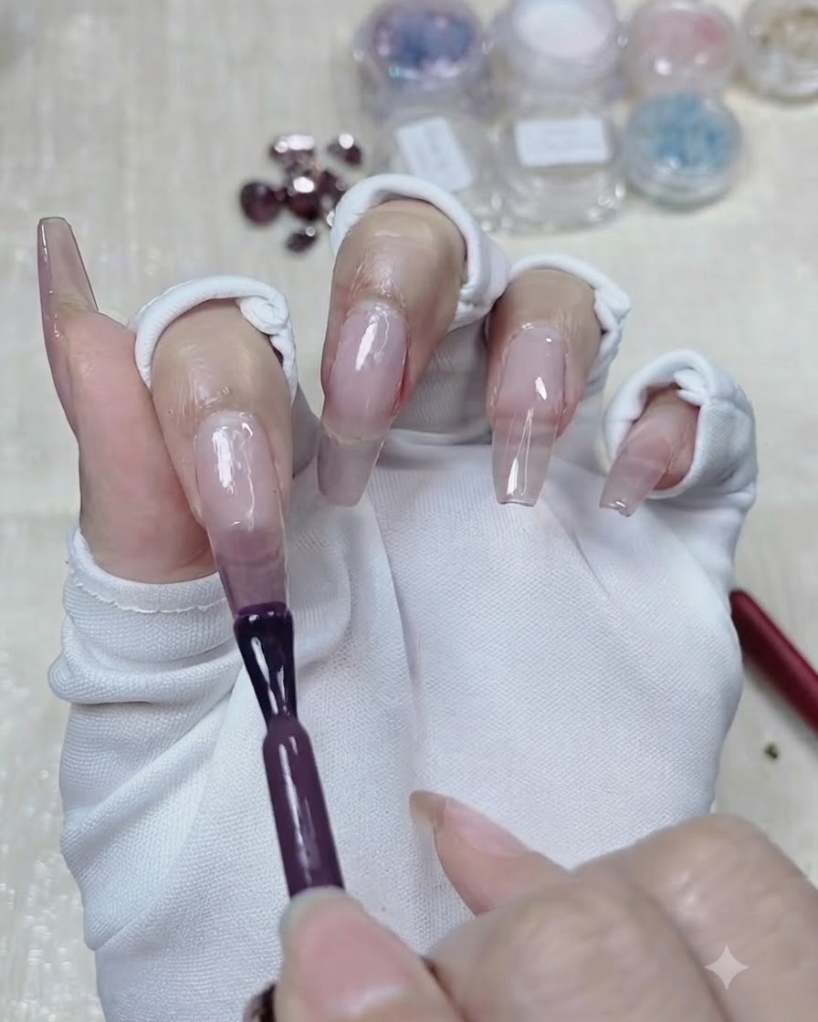 Ein Pinsel trägt eine zweite, tiefere Schicht Taro-Lila-Gel auf die obere Hälfte des Nagels auf.