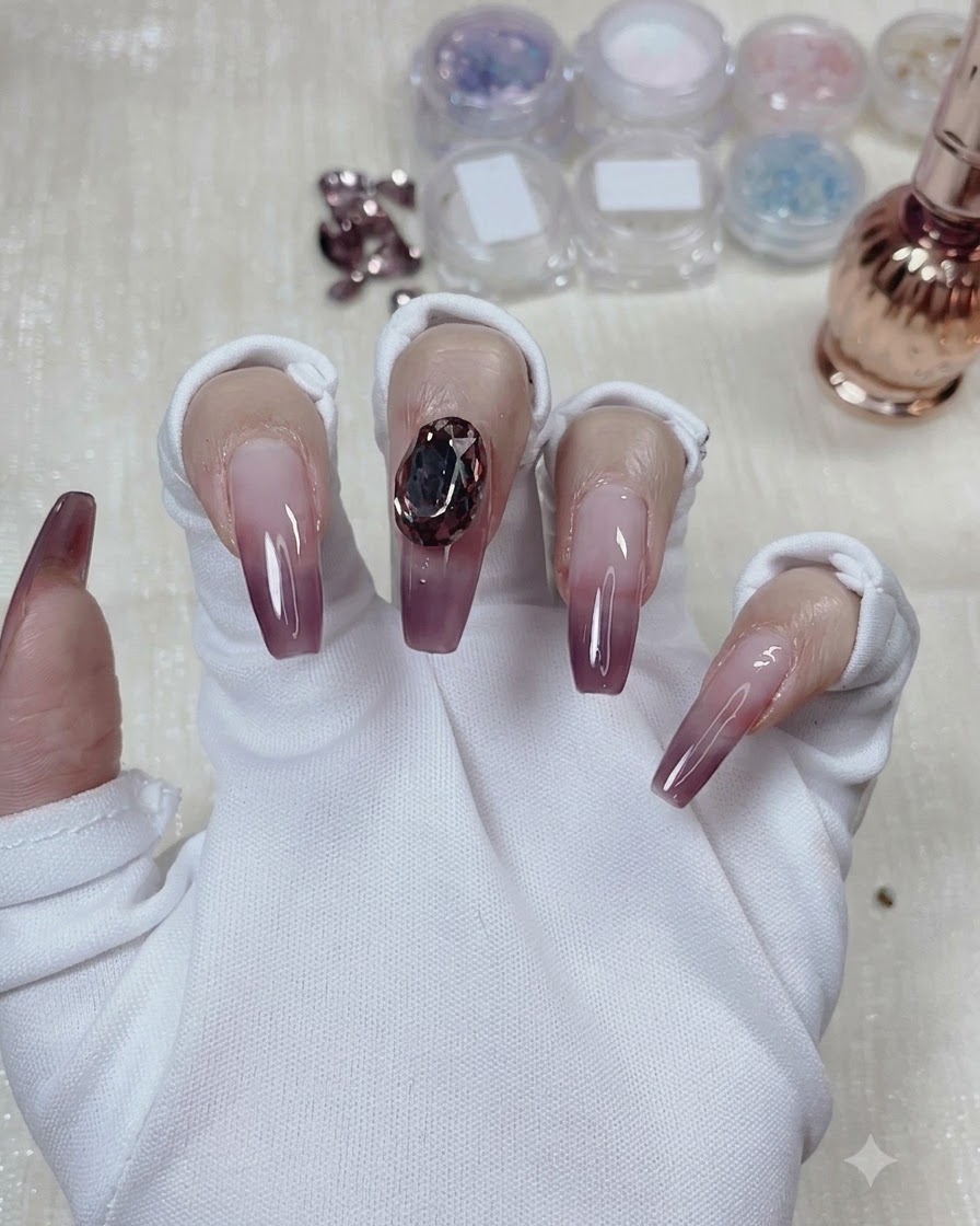 Ein großer, taubeneiförmiger Kristall, der sicher in der Mitte des Taro-Lila-Gradient-Nagels befestigt ist.
