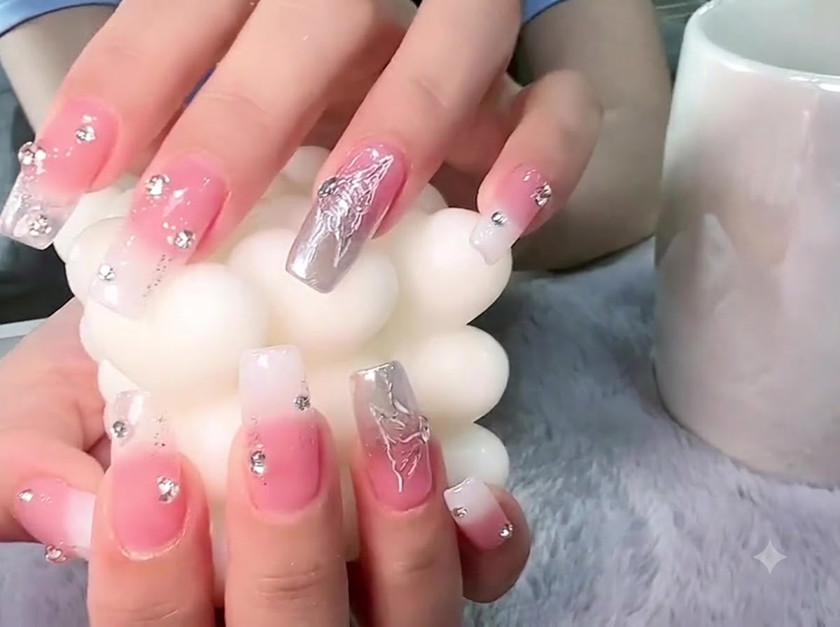 Hände halten eine strukturierte weiße Stumpenkerze, mit Fokus auf die 3D-Schmetterlings-Nailart in Silber.