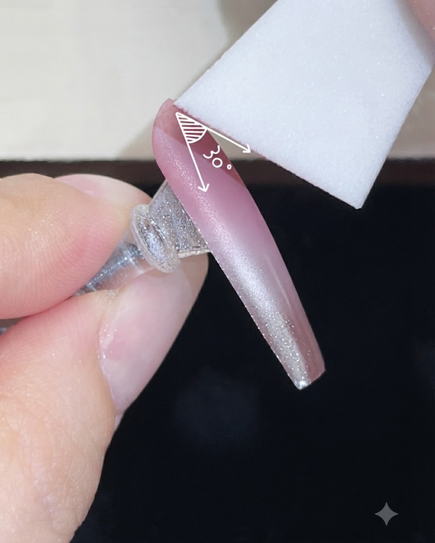 Ein Schaumstoffschwamm trägt eine zweite Schicht Farngel in einem kontrollierten Winkel auf einen Nude-Verlaufsnagel auf.