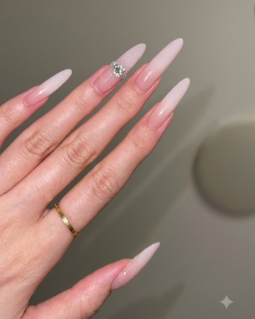 Eine Nageldesignerin verwendet einen Pinsel in einer sanften Klopfbewegung, um einen milchweißen Ombré-Verlauf auf einer Nude-Basis zu erzeugen.