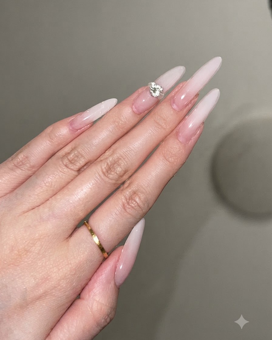 Ein kleiner Tropfen klaren Gel-Klebers wird auf die Mitte eines verzierten Stiletto-Nagels platziert.