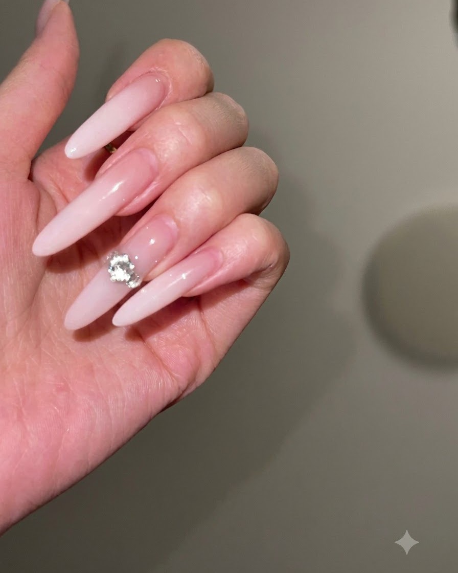 Eine Nagelfeile formt und verschmälert die Seitenkanten eines langen Stiletto-Nagels.