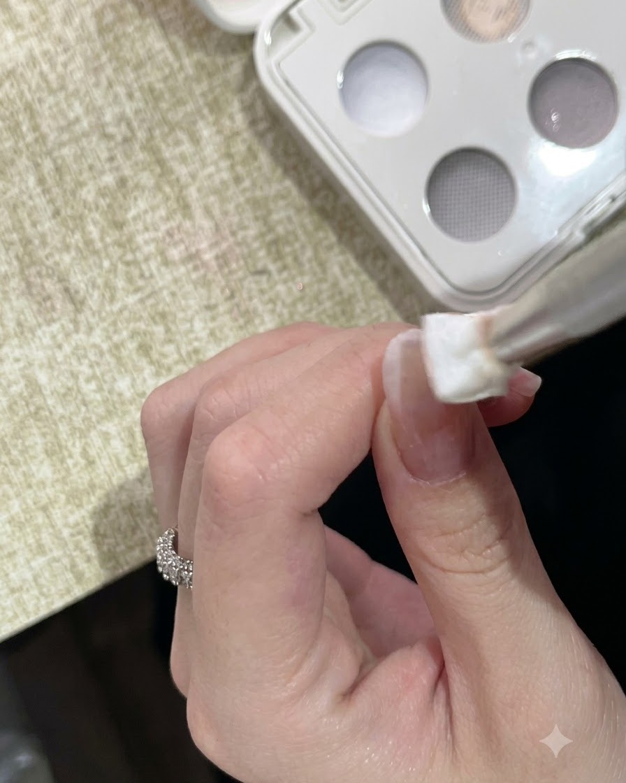 Ein Schwammwerkzeug tupft weißes Solid-Clay-Gel auf die Spitze eines manikierten Fingernagels.