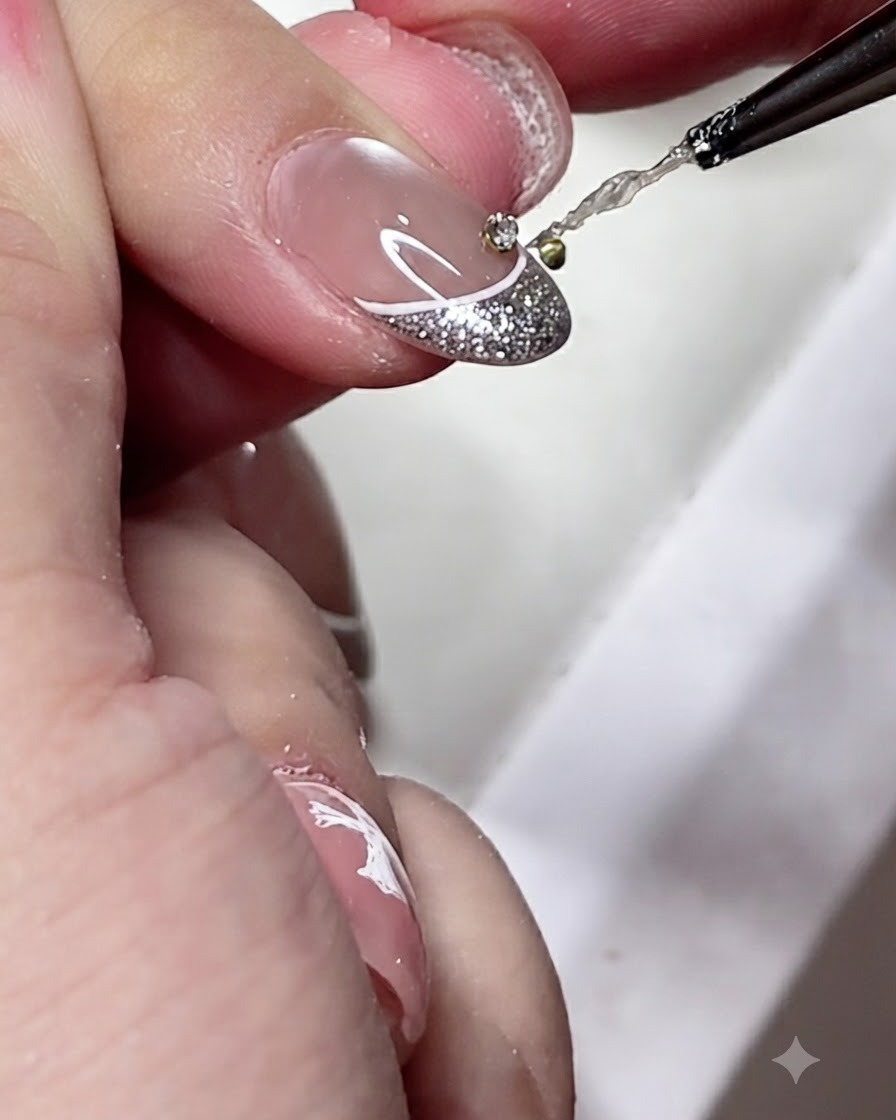 Ein Detailpinsel trägt einen kleinen Tropfen klaren Gel-Klebers auf die Mitte einer dekorierten French-Maniküre-Spitze auf.
