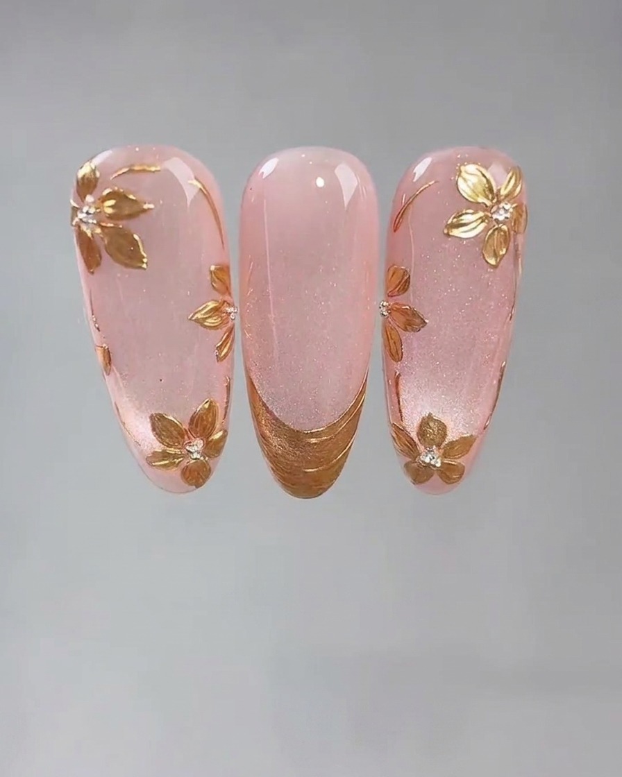 Eine Detailaufnahme eines feinen Werkzeugs, das einen kleinen Punkt klebrigen Nagelklebers auf einen rosa Cat-Eye-Gelnagel setzt.