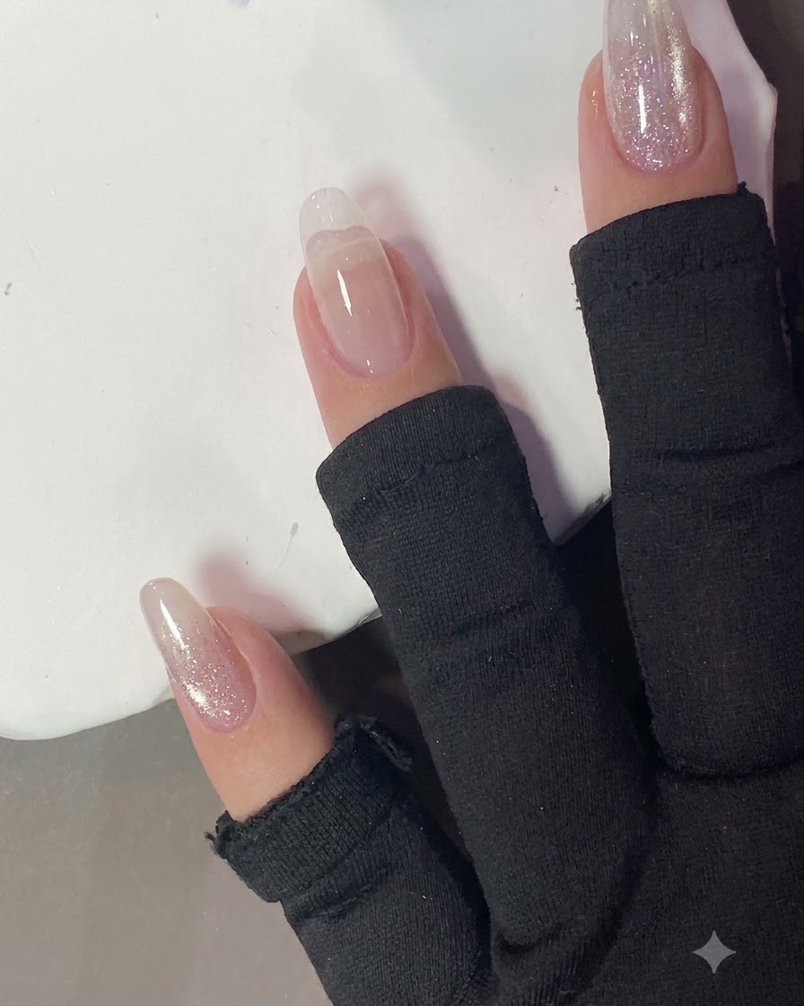 Ein Wattepad wischt die Oberfläche eines ausgehärteten Nagels ab.