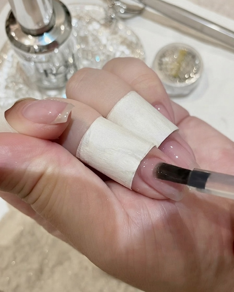 Nägel mit einem großen Kristall-Edelstein härten unter einer UV-Lampe aus.