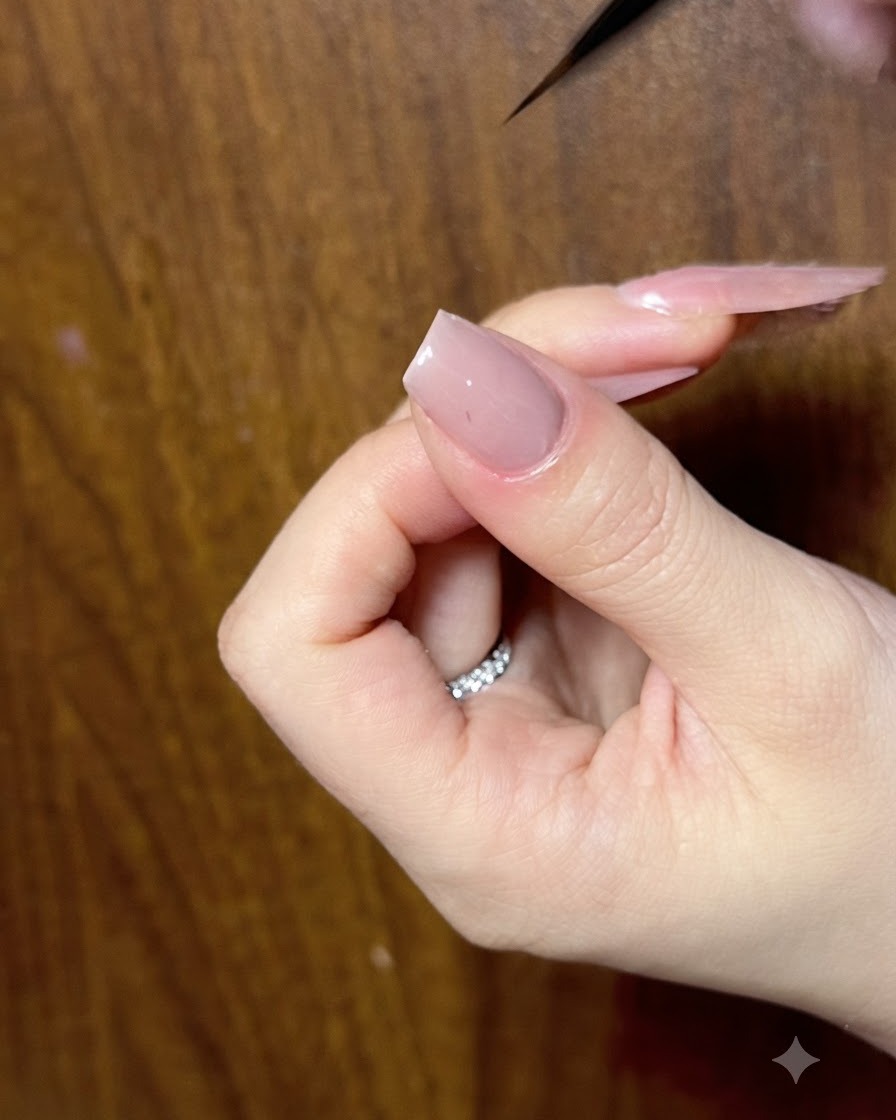 Nahaufnahme eines Nagels, der mit einem feinen Liner-Pinsel korrigiert wird, um saubere Schleifenkonturen zu garantieren.