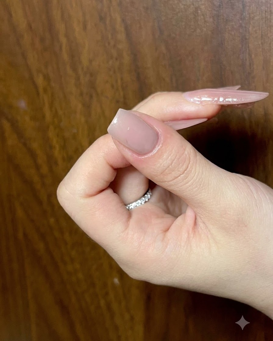 Nahaufnahme eines Nude-Manikürenagels, der detaillierte Cat-Eye-Gel-Striche für das Schmetterlingsflügel-Art erhält.
